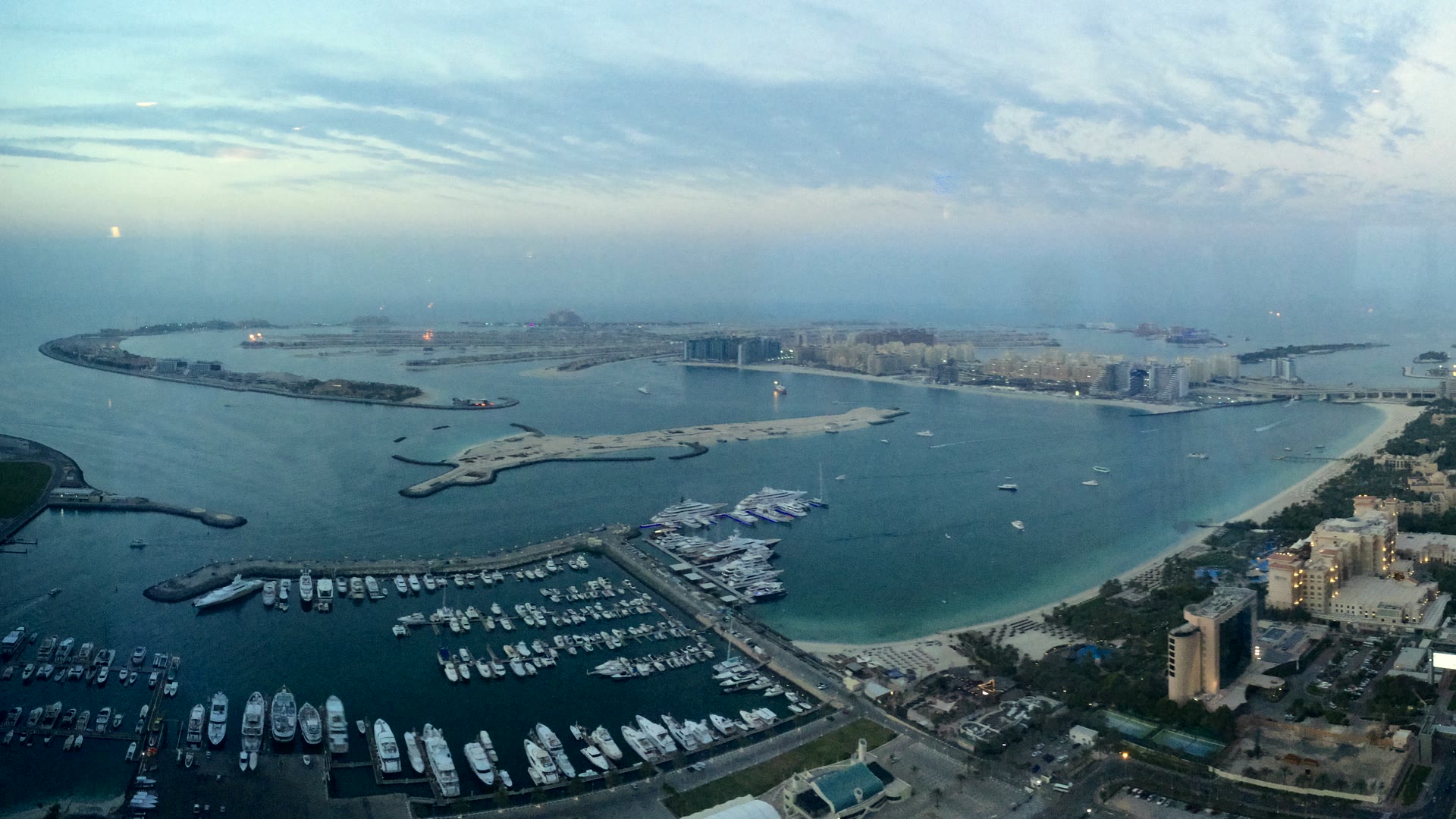 Palm Jumeirah and the Dubai Marina yacht harbour seen from above at dusk